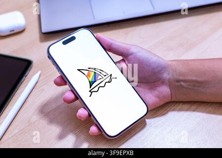 Hand holding an iPhone with the Midjourney app logo. Stock Photo