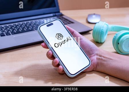 Hand holding an iPhone with the OpenAI app logo. Stock Photo