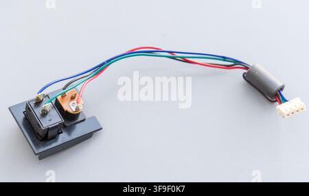 Colorful wires connect switches and a multipin connector on a light grey background Stock Photo