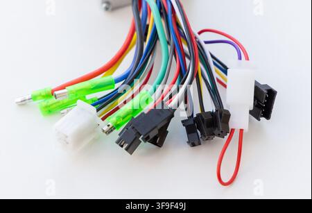 Various colorful electrical wires with connectors lie on a white background Stock Photo