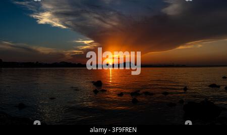 Scenes of a partial solar eclipse 2026  observed over the Mediterranean Sea in Denia. The sunset creates a striking golden light effect on the clouds. Stock Photo