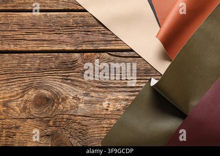 Various colored leather samples on a rustic wooden background, material selection and craftsmanship Stock Photo