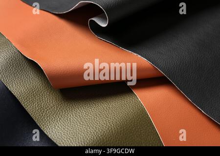 Assortment of textured Faux leather fabric swatches in black, brown, and olive green for upholstery and fashion design Stock Photo