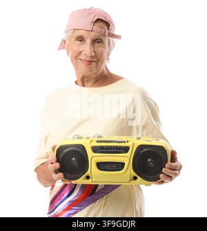 Smiling senior woman in a pink baseball cap holding a yellow boombox enjoying music and retro style isolated on white background Stock Photo