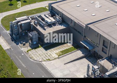 Aerial view of an industrial factory building featuring complex technical installations, ventilation systems on the roof, and loading docks in Poland. Stock Photo
