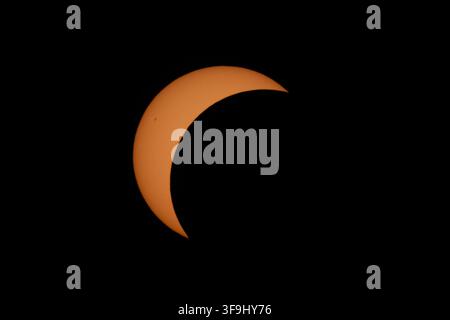 Aerial view of a partial solar eclipse with the moon partially covering the sun in the dark sky over Mulhouse, Grand Est, France. Stock Photo