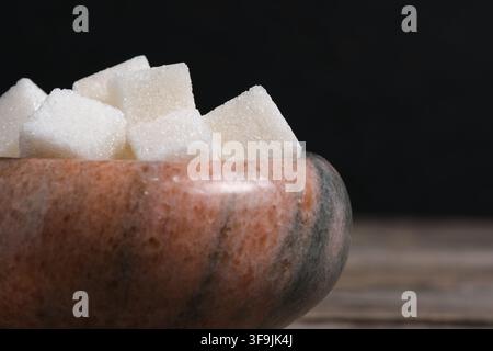 Macro close up view white sugar cubes in marble bowl on rustic wooden table surface Stock Photo