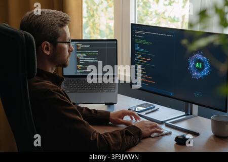 Professional programmer using an AI coding assistant or Artificial intelligence agent on a desktop computer while writing software code in a home office. Vibe coding concept. Space for text Stock Photo