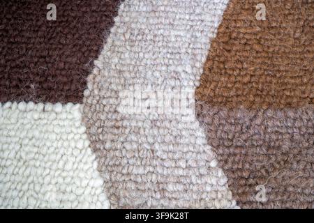 Close-up of textured knitted wool fabric in warm neutral brown, beige and cream tones Stock Photo