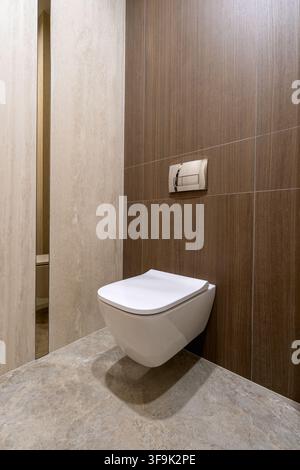 Modern minimalist bathroom interior with a wall-mounted white toilet Stock Photo