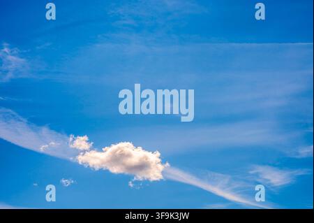Single white cloud on vibrant blue sky background with copy space for text Stock Photo