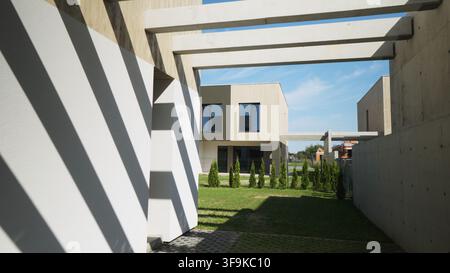 Modern minimalist house architecture featuring concrete elements and strong shadow patterns on a sunny day Stock Photo