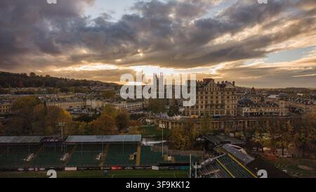 Aerial view of Bath Abbey and the historic skyline of Bath at sunset with autumn trees and Parade Gardens in the foreground, Bath, England, United Kin Stock Photo