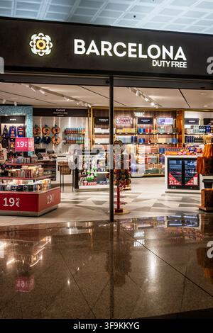 The Barcelona Duty Free shop stands open with illuminated signage and product displays inside a near-empty departure area at Barcelona airport. Stock Photo