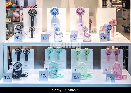 Handheld battery-powered fans are displayed for sale with euro price tags in a shop, reflecting seasonal consumer demand for personal cooling Stock Photo