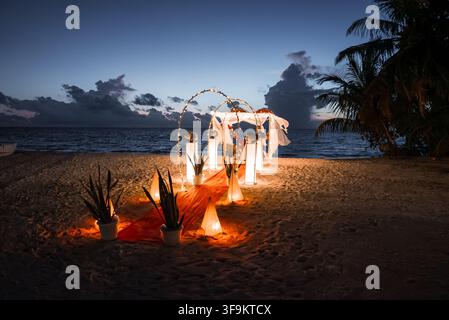 Romantic wedding arch and dinner setup on a beach in Maldives at dusk Stock Photo