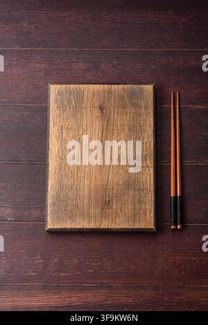 A square wooden cutting board for home food preparation. A wooden cutting board serving as a food background for your design Stock Photo