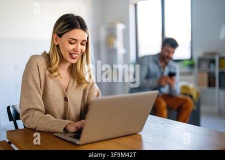 Woman working on laptop online, checking emails and planning on the internet at home office Stock Photo
