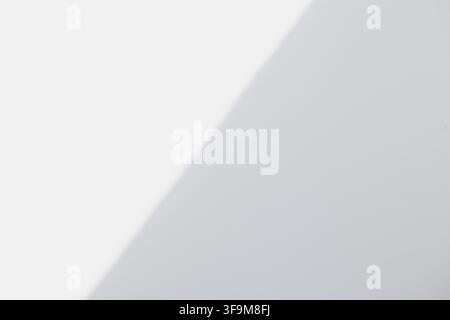Minimalist abstract background with soft diagonal shadow overlay on clean white and light grey surface. Modern neutral backdrop template with copy spa Stock Photo