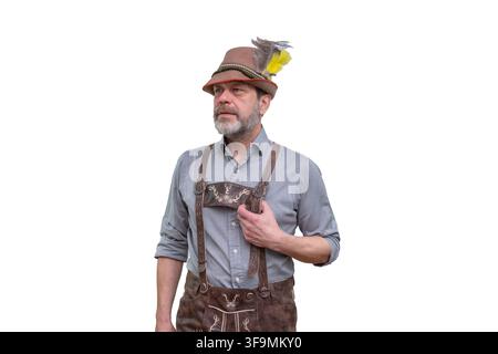 Bearded man wearing traditional Bavarian clothing and feathered hat stands isolated on white. Stock Photo