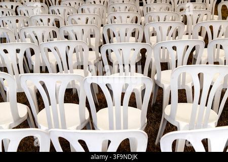 Rows of empty plastic chairs awaiting an audience and creating a sense of anticipation for an outdoor event Stock Photo