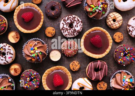 Dessert background with a selection of sweets. Top view on a dark stone background. Stock Photo