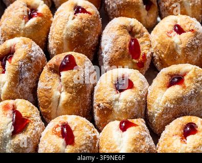 Delicious homemade jam doughnuts oozing with fruity jam and coated in a generous layer of sugar Stock Photo