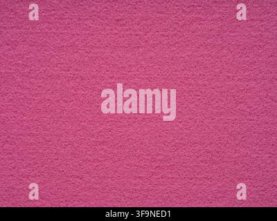 Full frame close up of vivid pink felt sheet showing its soft fibrous surface, a flat textile background with plenty of copy space for text. Stock Photo