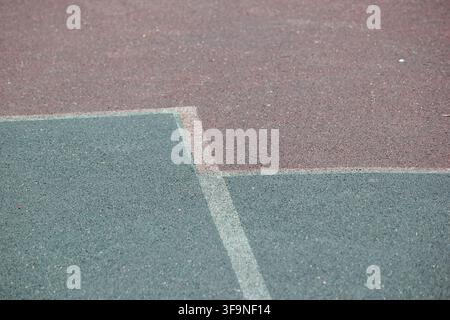 Detailed close up of painted corner lines on a textured asphalt basketball court surface Stock Photo