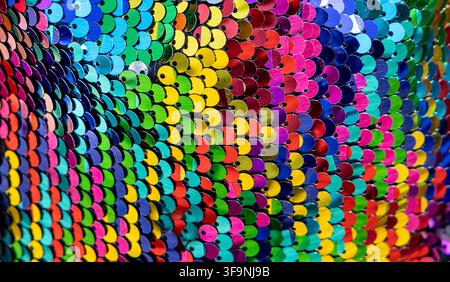 Bright colourful sequinned fabric creating a vibrant shimmering background for parties and special events Stock Photo