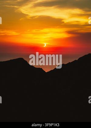 Sant Elm, Balearic Islands, Spain - 12 August 2026: Aerial view of the solar eclipse over the silhouette of Sa Dragonera island during the golden hour Stock Photo