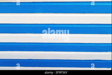 Blue and white striped beach hut wall evoking sunny seaside holidays and hot summer days Stock Photo