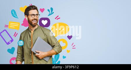 Happy Young Man Using Laptop And Smiling, Creative Office Concept With Colorful Graphics Stock Photo