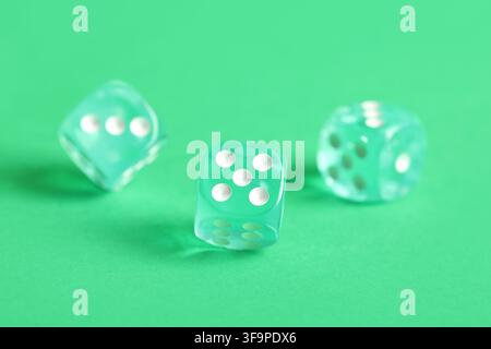Turquoise game dices on green background Stock Photo