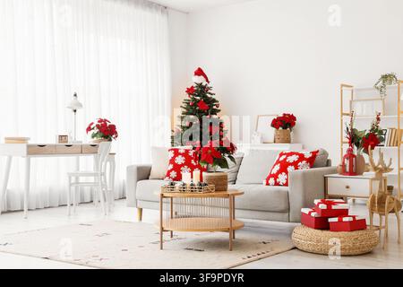 Modern living room decorated for christmas with a festive tree poinsettias and gift boxes holiday season interior design Stock Photo