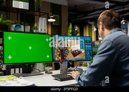 IT engineer architect uses green screen and CAD software to create a modern layout, 3D modeling program and chroma key on dual monitors. Architectural design virtual assets. Stock Photo