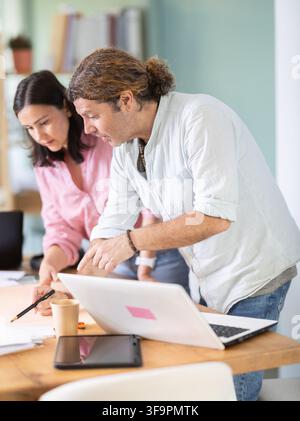 Two architects discuss a building plan in company office Stock Photo