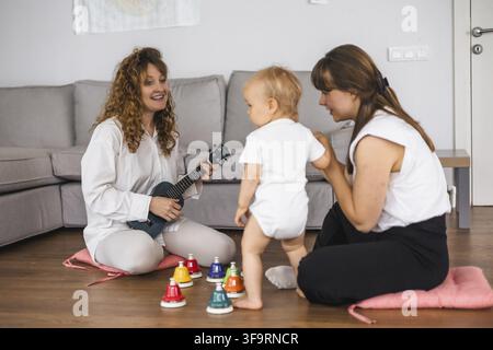 Playful music session with a toddler, a woman, and colorful instruments Stock Photo