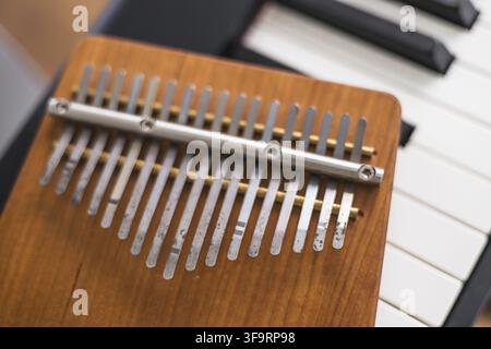 Close-up view of the metal tines on a wooden kalimba over piano keys Stock Photo