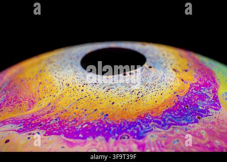 Multicolored abstract chaotic pattern inside of the soap bubble, closeup. Stock Photo