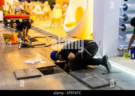 Sao Paulo, SP, Brazil, August 03, 2026: Construction workers and technician crew hard at work installing electrical wiring and flooring infrastructure Stock Photo