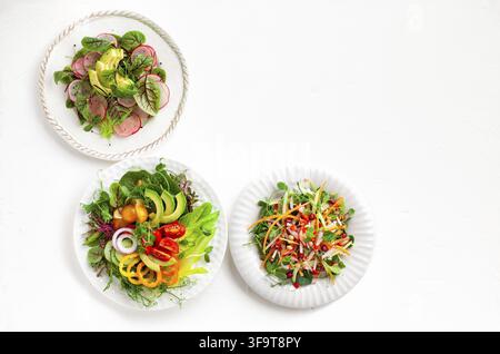 Various healthy salads of fresh vegetables, fruits and microgreens on table. Clean eating, lunch bowl. Top view. Concept taste of home meal Stock Photo