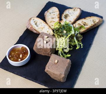 Jam with bread tapas and herbs on the black plate Stock Photo