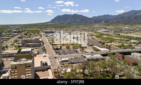 Wide aerial view of Colorado Springs city grid with straight street leading toward Rocky Mountain horizon Stock Photo