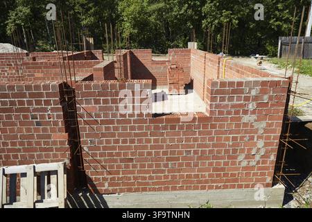 Brick walls rise up at a construction site. House under construction Stock Photo