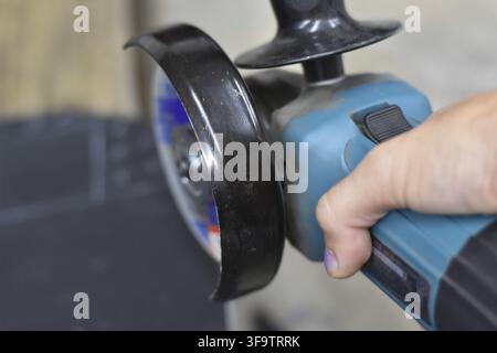 Using a power tool in my garage to work on a welding project. Angle Grinder Blade Ready to Cut Metal. Stock Photo