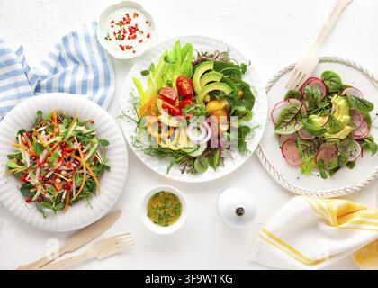 Various healthy salads of fresh vegetables, fruits and microgreens on table. Clean eating, lunch bowl. Top view. Concept taste of home meal Stock Photo