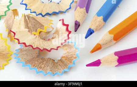Sharpened colorful pencils and wood shavings, closeup macro. Stock Photo