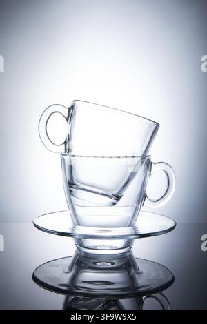 Two isolated transparent tea cups with saucers Stock Photo