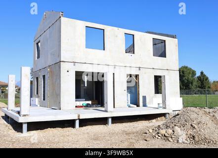 New residential building under construction with raw concrete prefab walls and thermal insulation board partially installed. Stock Photo